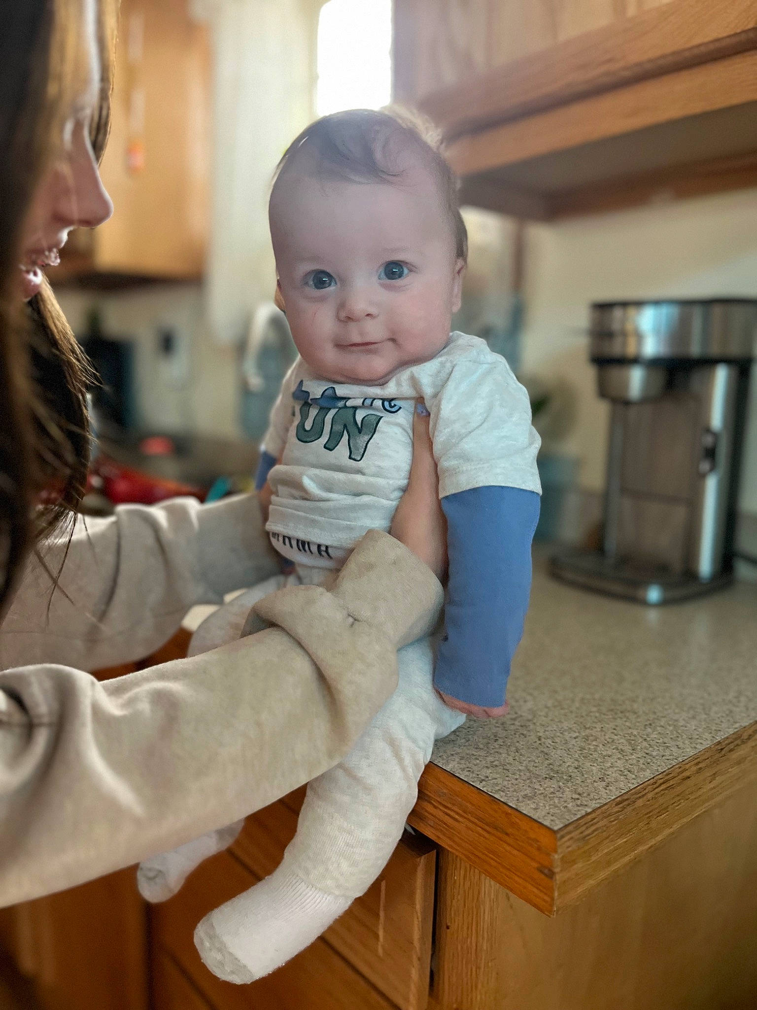 Adam is registered to the contest to win money with this photo: baby, baby_toddler_clothing, cheek, child, comfort, eye, flooring, fun, fur, gesture, happy, joint, kitchen_appliance, person, room, sitting, skin, sleeve, smile, standing