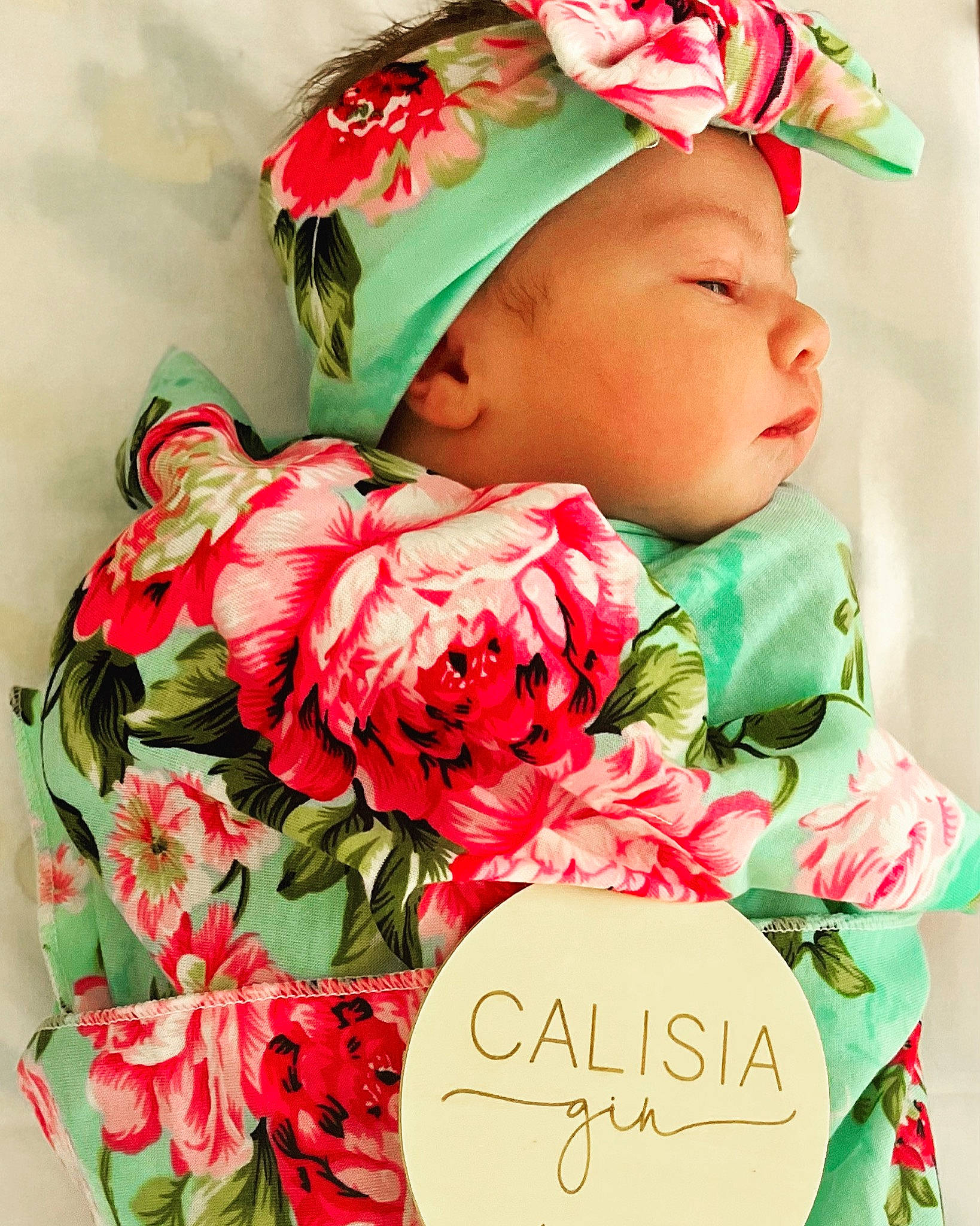Cali is registered to the contest to win money with this photo: baby, baby_toddler_clothing, bouquet, cap, dress, face, flower, flower_arranging, happy, hat, headgear, headpiece, people_in_nature, person, petal, photograph, pink, plant, red, textile