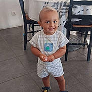 Luca a rejoint le concours — aidez-le/la à gagner de superbes lots ! toddler, child, smiling, standing, indoor, dining_room, table, chairs, floor, tile, clothing, shoes, cute, person, young_child, home, decor, happy, portrait, casual