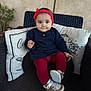 Jade a rejoint le concours — aidez-le/la à gagner de superbes lots ! baby, infant, child, headband, bow, pillow, cushion, wicker_chair, chair, red_leggings, navy_dress, shoes, sneakers, portrait, smile, big_eyes, cheeks, plant, indoors, cozy