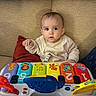 animal_illustrations, baby, child, clothing, colorful, couch, curious, cushion, expression, face, furniture, hands, home, indoor, infant, numbers, piano, play, seated, toy