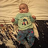 baby, bed, blanket, child, clothing, cute, face, furniture, indoors, infant, person, plush, portrait, sleepwear, smile, stitch, toddler, toy, wearing, young
