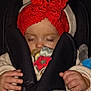 baby, sleeping, pacifier, car_seat, red_headband, knitted, bow, blanket, hands, cozy, infant, child, cute, face, closed_eyes, warm_clothing, soft, indoors, comfort, resting