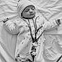 baby, newborn, sleeping, onesie, hat, blanket, black_and_white, infant, child, cute, peaceful, clothing, animal_illustration, tree_illustration, soft_texture, portrait, indoors, resting, small_person, toddler