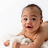 Desmond joined the competition — help win amazing prizes! baby, infant, child, cute, smile, face, skin, curly_hair, lying_down, blanket, soft_texture, expression, portrait, closeup, hands, eyes, young, adorable, happy, natural_light