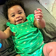 Brooklyn is registered to the contest to win money with this photo: baby, infant, smile, green_clothing, dragonfly_pattern, diaper, happy, cute, lying_down, soft_surface, child, skin, face, hand, legs, indoors, portrait, toddler, person, bright_colors