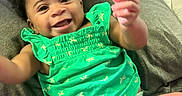 Brooklyn is registered to the contest to win money with this photo: baby, bright_colors, child, cute, diaper, dragonfly_pattern, face, green_clothing, hand, happy, indoors, infant, legs, lying_down, person, portrait, skin, smile, soft_surface, toddler