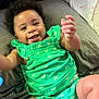 baby, infant, smile, green_clothing, dragonfly_pattern, diaper, happy, cute, lying_down, soft_surface, child, skin, face, hand, legs, indoors, portrait, toddler, person, bright_colors