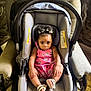 Brooklyn is registered to the contest to win money with this photo: baby, child, car_seat, pink_dress, sandals, hair_bows, indoor, chair, cushion, person, portrait, cute, infant, seated, looking_at_camera, furniture, expression, small_child, footwear, headwear