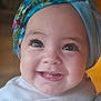 baby, infant, child, smile, teeth, eyes, long_eyelashes, headscarf, scarf, headwrap, cheeks, portrait, closeup, clothing, onesie, indoors, soft_lighting, happy, cute, skin