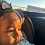 toddler, child, face, car_seat, window, sunlight, shadow, clothing, person, portrait, indoor, closeup, expression, seat, car, head, hand, daylight, young_child, casual