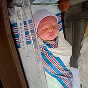 Dustin is registered to the contest to win money with this photo: newborn, baby, swaddled, hospital_bassinet, blanket, cap, sleeping, infant, striped_blanket, hospital, bed, peaceful, cute, person, indoor, medical, resting, child, soft, newborn_care