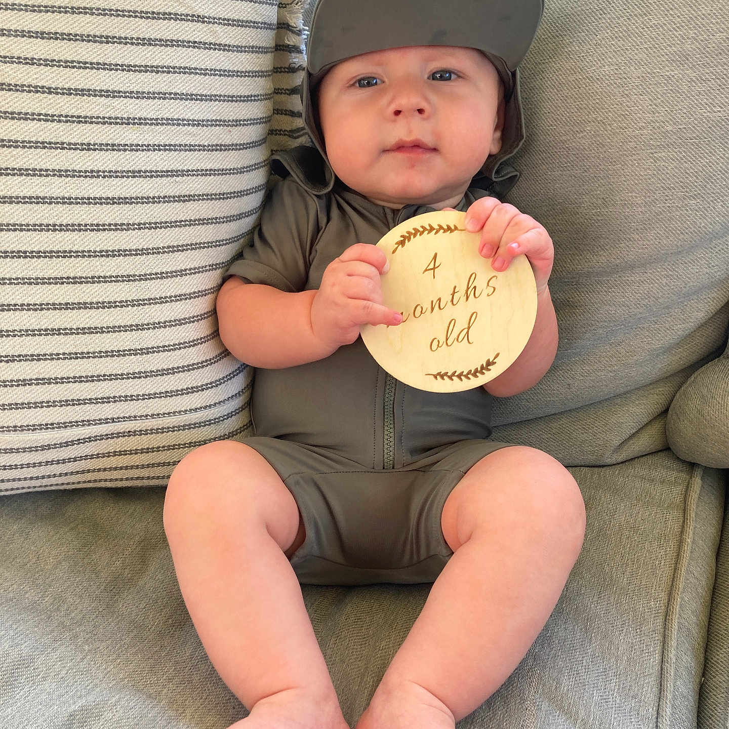 Stetson Hayes is registered to the contest to win money with this photo: baby, child, clothing, comfortable, couch, cute, expression, fabric, face, feet, hands, hat, home, indoor, infant, legs, pillow, sitting, striped_pillow, wooden_sign