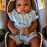 Marquiez is registered to the contest to win money with this photo: baby, child, denim_overalls, car_seat, blue_socks, infant, cute, portrait, indoor, clothing, seatbelt, comfortable, adorable, young_child, person, skin, face, hands, legs, casual_wear