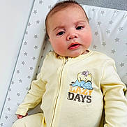 Mylo joined the competition — help win amazing prizes! baby, changing_pad, child, closeup, cute, expression, face, hand, head, indoor, infant, onesie, person, portrait, resting, sleepy, soft_lighting, star_pattern, yellow_clothing, young