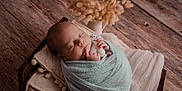 Enzo participe au concours pour gagner de l'argent avec cette photo : baby, blanket, child, cozy, cute, dried_flowers, indoors, infant, knitted_toy, newborn, peaceful, pillow, portrait, resting, serene, sleeping, soft_texture, swaddled, wooden_bed, wrapped