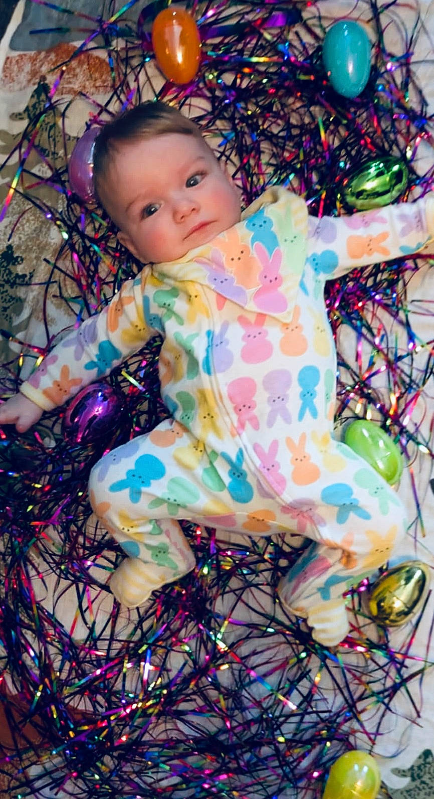 Theo is registered to the contest to win money with this photo: accessories, baby, balloon, clothing, costume, dress, egg, face, food, footwear, happy, head, lighting, pajamas, person, photography, portrait, purple, smile, sphere