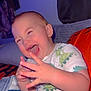 Ronan is registered to the contest to win money with this photo: toddler, child, laughing, happy, dinosaur_pajamas, hands, couch, blanket, indoor, baby, smiling, cute, playful, person, face, clothing, cozy, home, seated, joy