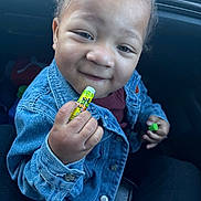 Marcellous is registered to the contest to win money with this photo: candy, car_interior, child, close_up, clothing, cute, denim, denim_jacket, eyes, face, hand, happy, infant, lip_balm, portrait, seat, sitting, skin, smile, toddler