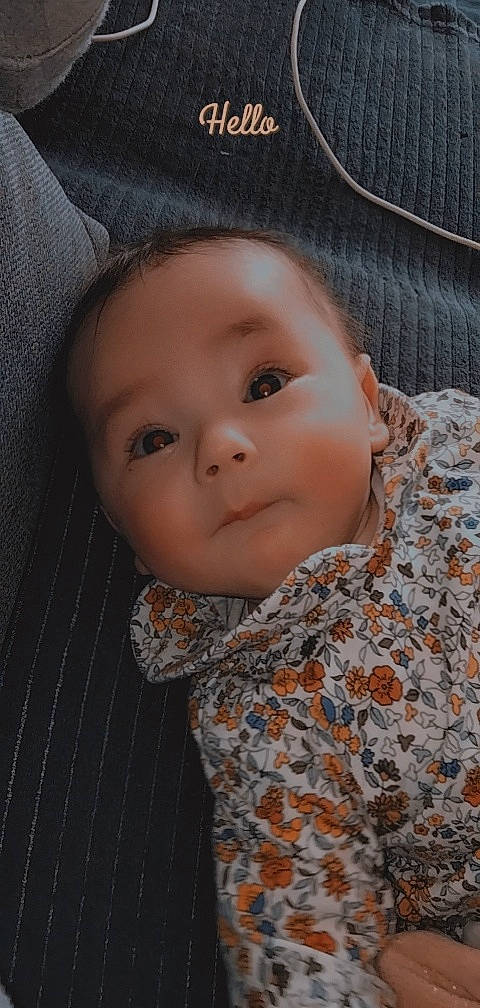 Inaya participe au concours pour gagner de l'argent avec cette photo : baby, baby_toddler_clothing, brown, cheek, child, close_up, collar, comfort, face, head, iris, lip, nose, outerwear, pattern, person, skin, sleeve, smile, textile