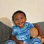 Omari joined the competition — help win amazing prizes! child, toddler, smiling, blue_clothing, patterned_pajamas, stuffed_bear, couch, indoor, happy, face, curly_hair, holding, snack, seated, black_hair, plush_toy, home, casual, cute, playful