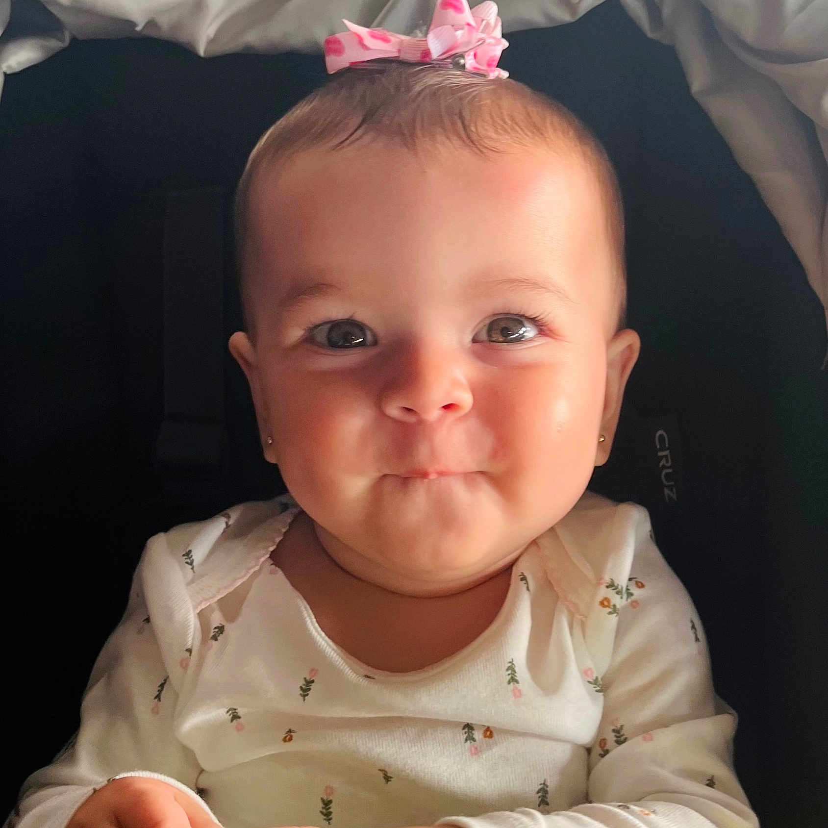 Sophia joined the competition — help win amazing prizes! adorable, baby, bow, child, clothing, cute, expression, eyes, face, floral, hair, hands, indoors, infant, person, portrait, sitting, smile, white, young