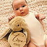 baby, infant, child, portrait, lying_down, smiling, wide_eyed, pink_outfit, blanket, plush_toy, bunny, stuffed_animal, wooden_sign, milestone, two_months, nursery, cozy, indoors, close_up, photography