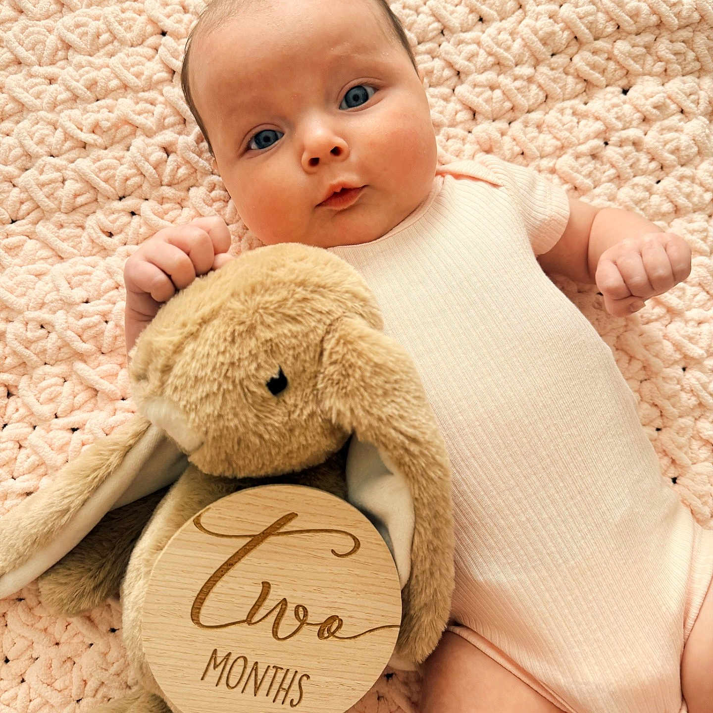 Lia joined the competition — help win amazing prizes! baby, infant, child, portrait, lying_down, smiling, wide_eyed, pink_outfit, blanket, plush_toy, bunny, stuffed_animal, wooden_sign, milestone, two_months, nursery, cozy, indoors, close_up, photography