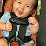 baby, blue_clothing, car_seat, child, cute, face, hands, happy, head, indoor, infant, legs, person, photography, pink_blanket, safety_harness, seat_belt, skin, smile, tongue_out