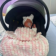 Elle joined the competition — help win amazing prizes! newborn, baby, infant_car_seat, blanket, pacifier, headband, bow, sleeping, indoors, hospital, bed, purple_curtain, soft_lighting, white_clothing, child, person, cute, resting, cozy, black_car_seat