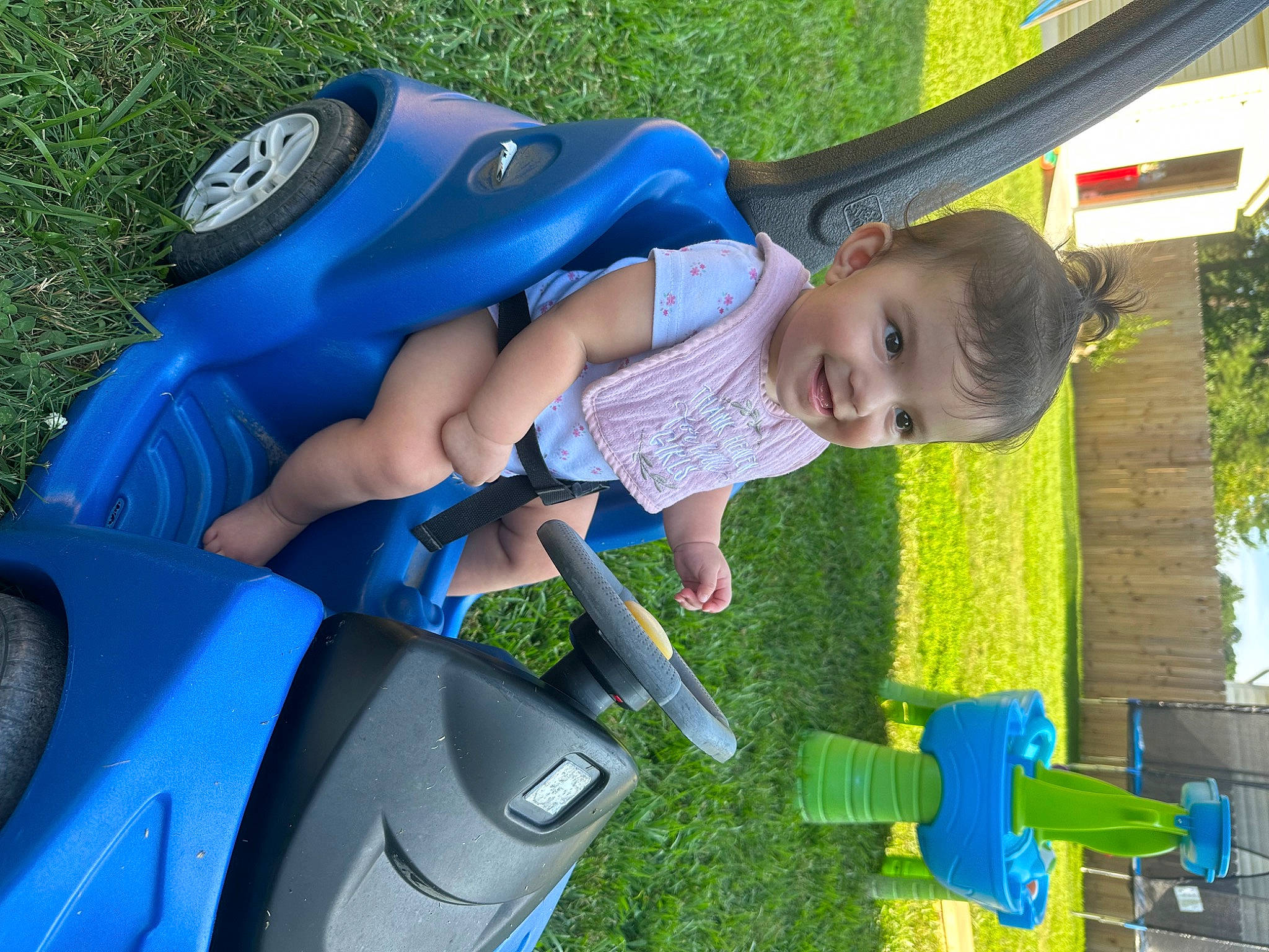 Helena is registered to the contest to win money with this photo: auto_part, automotive_exterior, baby, baby_toddler_clothing, blue, child, electric_blue, family_car, fun, grass, green, lawn, leisure, person, plant, recreation, smile, toddler, tree, vehicle