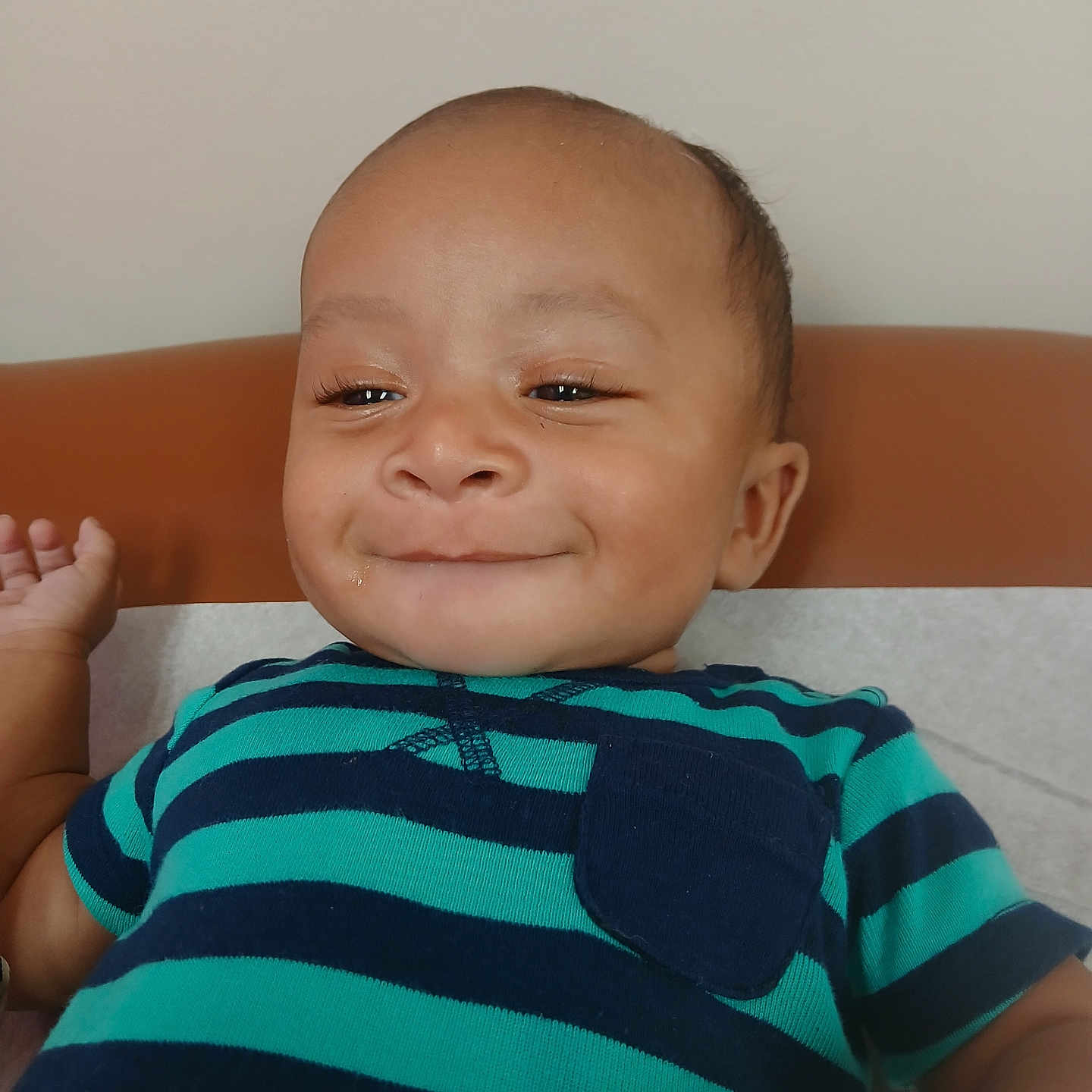 Malachi joined the competition — help win amazing prizes! adorable, baby, child, close_up, couch, eyes, face, hair, hand, happy, home, indoor, infant, navy_blue, photography, portrait, sitting, smiling, striped_shirt, turquoise