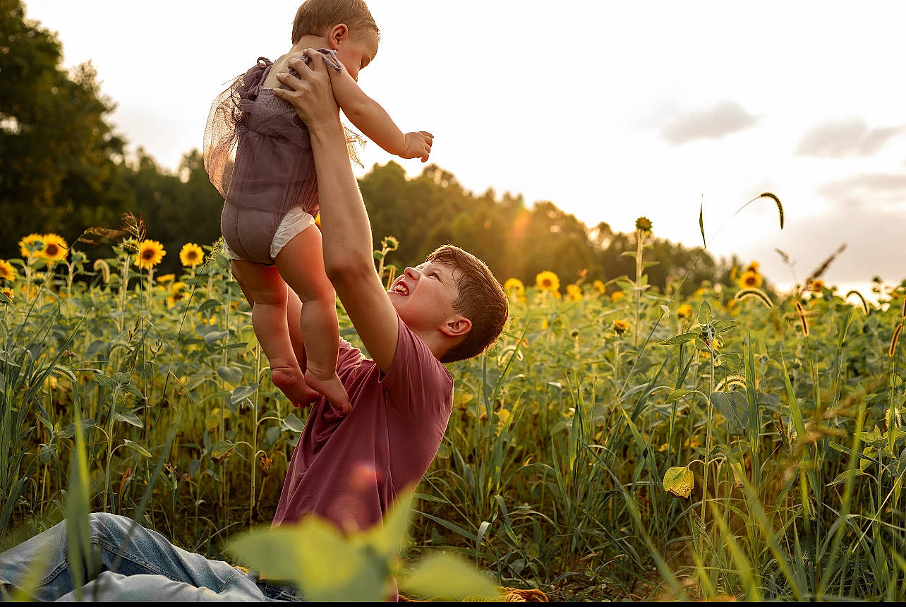 Jonah is registered to the contest to win money with this photo: agriculture, flash_photography, flower, fun, gesture, grass, grass_family, grassland, hand, happy, landscape, leaf, meadow, people_in_nature, person, plant, prairie, rural_area, sky, sunlight