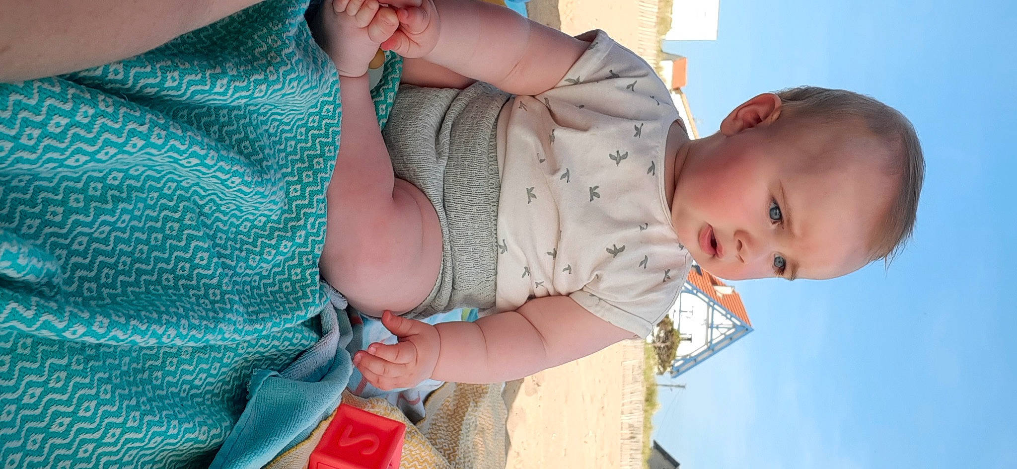 Paola participe au concours pour gagner de l'argent avec cette photo : abdomen, arm, baby, baby_toddler_clothing, blue, chest, child, dress, finger, hand, happy, human_body, joint, pattern, person, shoulder, skin, sky, smile, toddler