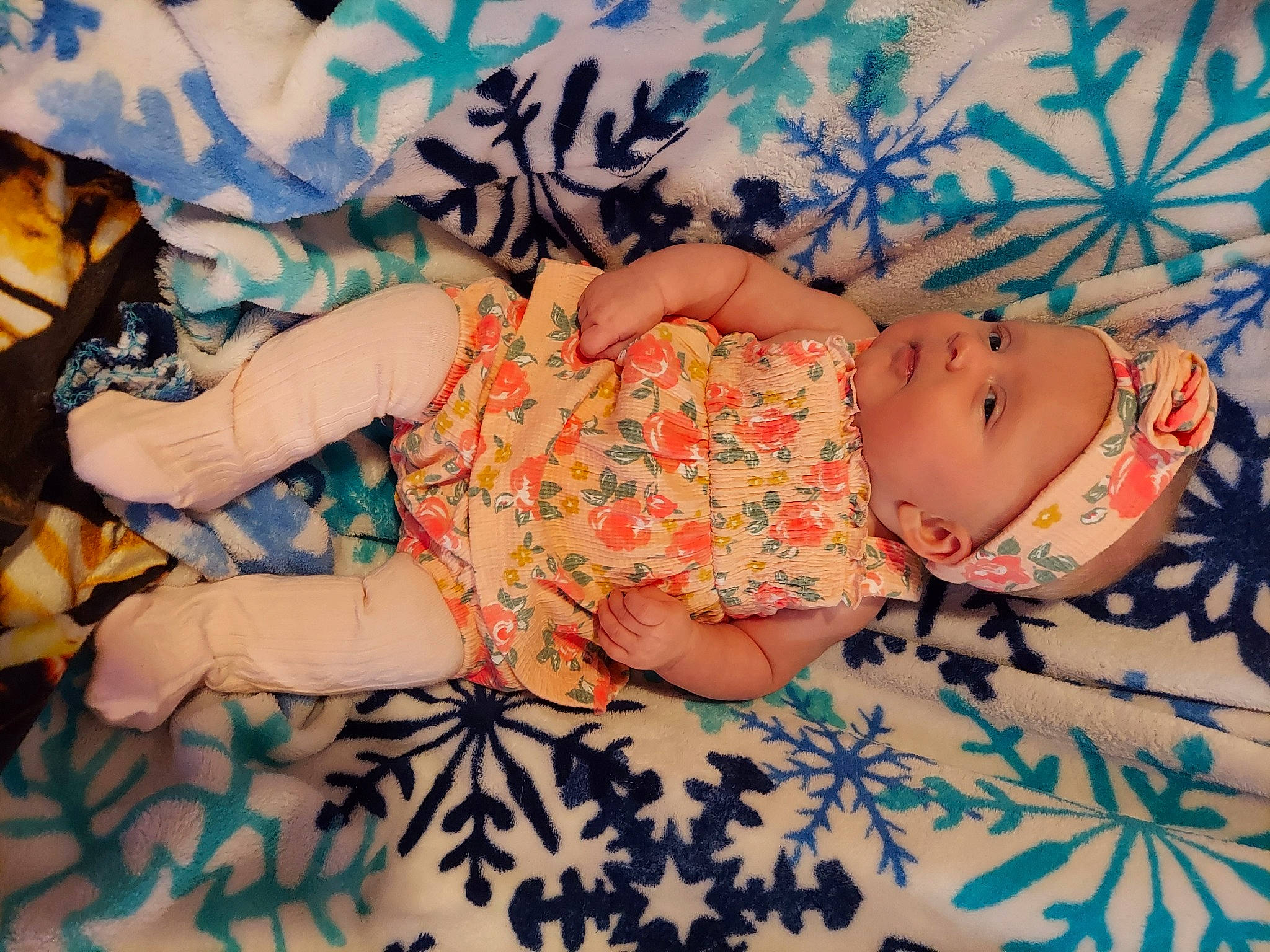 Amber is registered to the contest to win money with this photo: arm, baby_toddler_clothing, child, comfort, eye, finger, hand, head, headwear, human_body, human_leg, linens, pattern, person, pink, plant, room, skin, textile, thigh