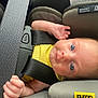 baby, infant, car_seat, child, safety_belt, yellow_clothing, blue_eyes, seatbelt, padded_seat, close_up, child_safety, infant_seat, baby_face, baby_hand, car_interior, child_restraint, seat_label, text_label, secure, cute