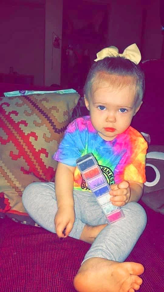 Lena is registered to the contest to win money with this photo: baby_toddler_clothing, cheek, child, comfort, couch, electric_blue, fun, hair, happy, head, human_leg, iris, knee, lap, magenta, person, pink, sitting, skin, thigh