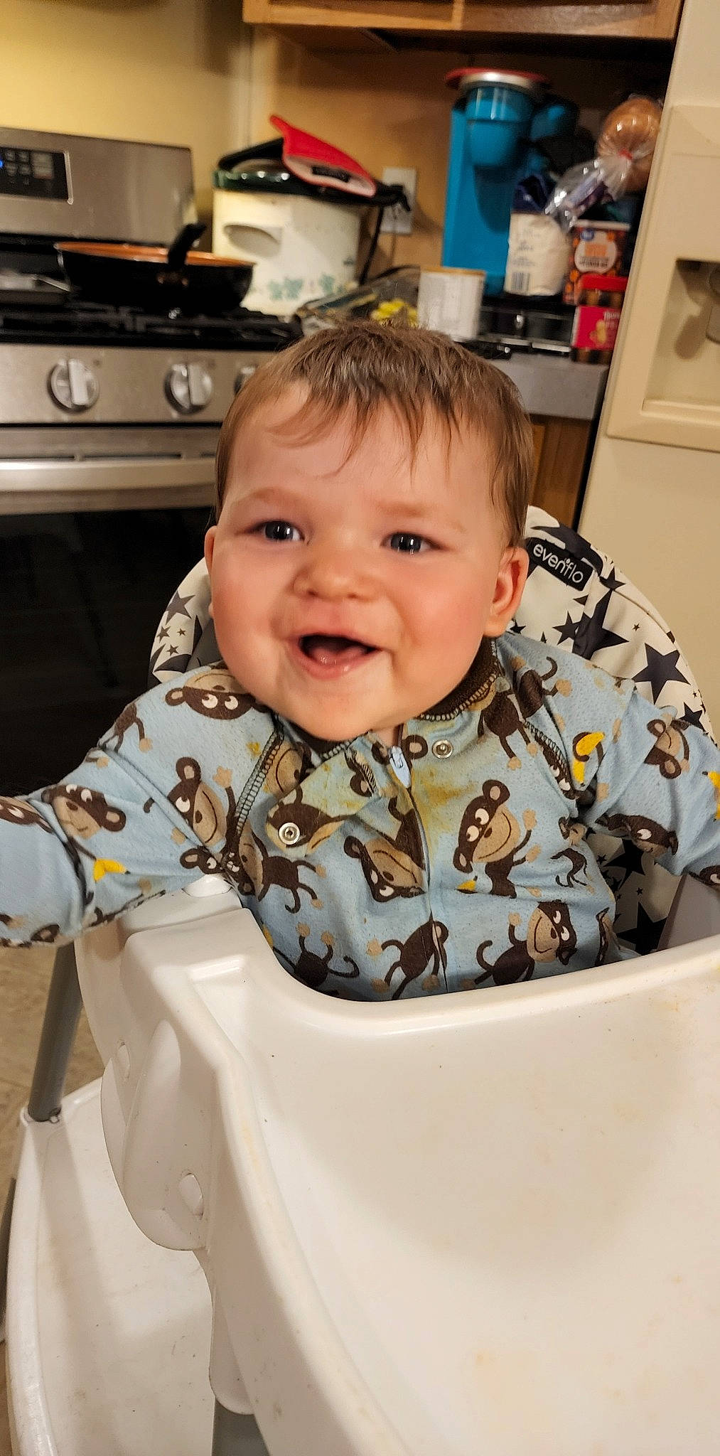 Austin is registered to the contest to win money with this photo: baby, baby_toddler_clothing, cheek, chin, eye, eyebrow, gas_stove, hair, happy, home_appliance, human_body, iris, kitchen_appliance, kitchen_stove, nose, person, shelf, sleeve, smile, t_shirt