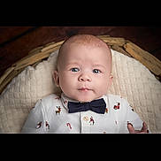 Greyson-James is registered to the contest to win money with this photo: baby, basket, blanket, blue_eyes, bow_tie, child, closeup, cozy, cute, face, holiday_theme, indoors, infant, looking_at_camera, lying_down, newborn, patterned_clothing, portrait, shirt, soft_texture