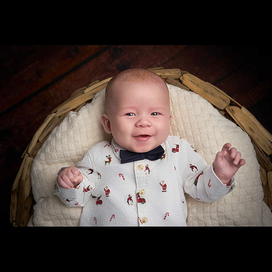 Greyson-James is registered to the contest to win money with this photo: baby, basket, blanket, bow_tie, candy_cane, child, clothing, cute, face, happy, holiday, indoor, infant, newborn, person, portrait, santa_claus, shirt, smiling, wood_floor