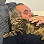 Angelo participe au concours pour gagner de l'argent avec cette photo : adult, animal, casual, cat, closeup, comfort, couch, domestic_animal, face, furniture, home, human_hand, indoor, man, pet, pillow, relaxing, resting, sleepy, tabby_cat