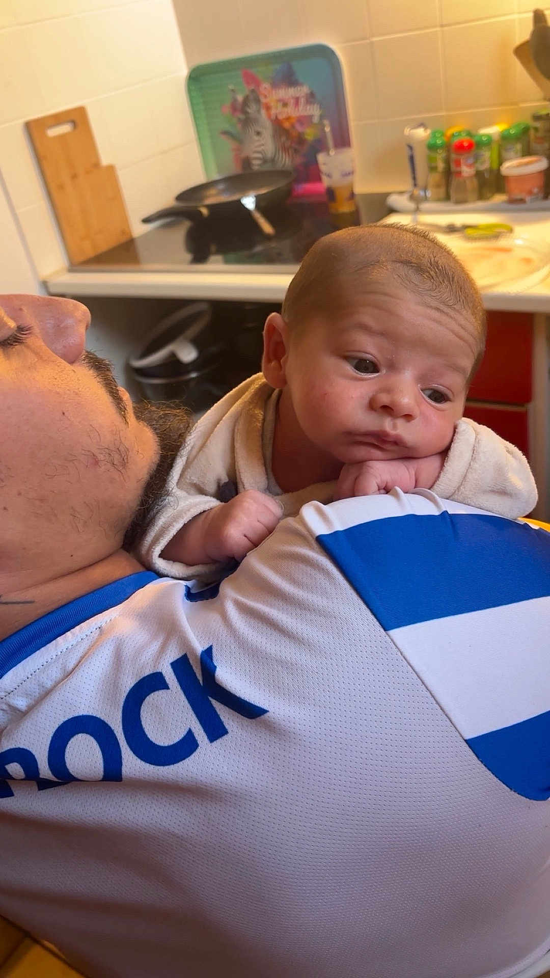 Tiago participe au concours pour gagner de l'argent avec cette photo : baby, adult, shoulder, kitchen, stove, spices, shirt, white, blue, person, face, resting, clothing, indoor, portrait, beard, cooking, utensils, food, thoughtful