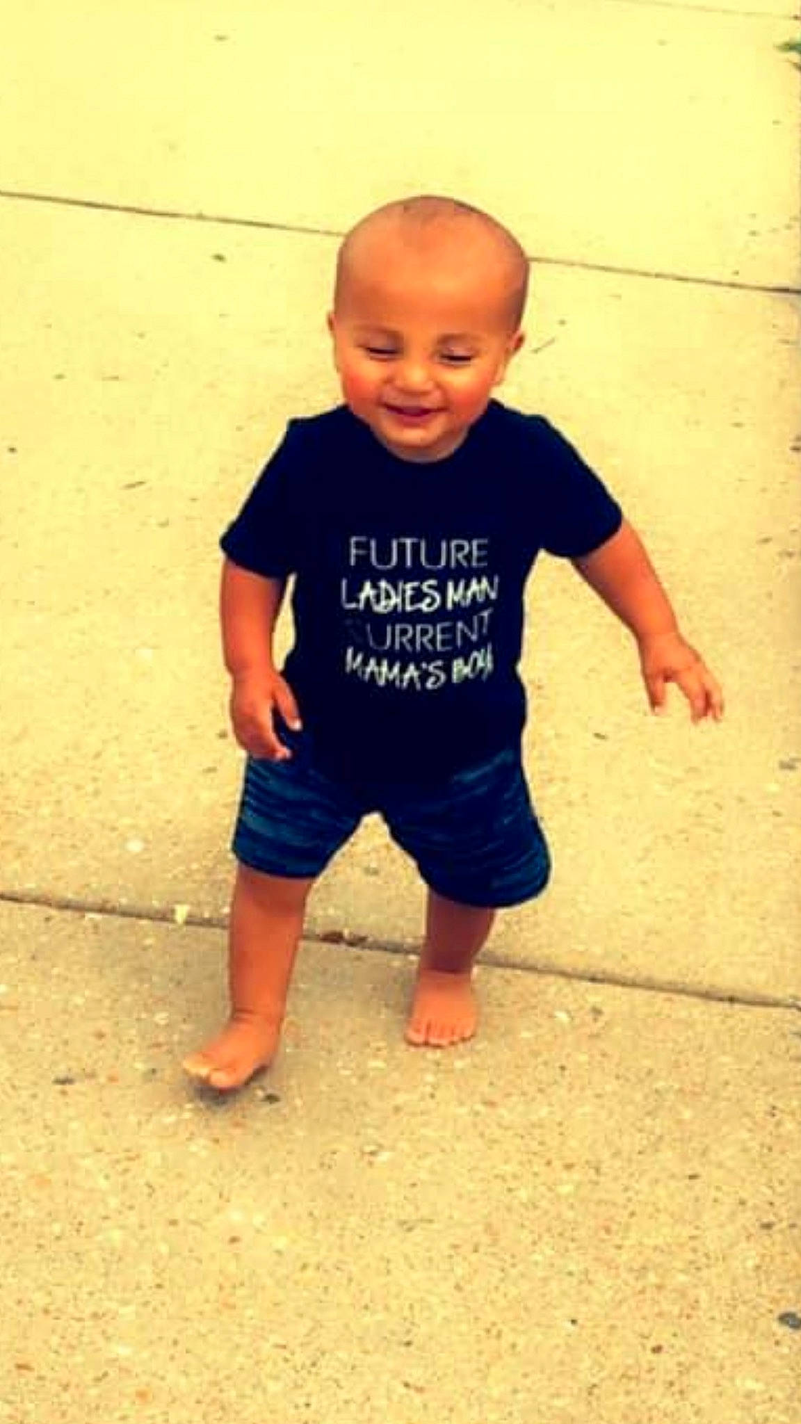 Jakob is registered to the contest to win money with this photo: baby, barefoot, child, floor, fun, head, joy, person, play, skin, sleeve, smile, standing, t_shirt, toddler, vacation, yellow