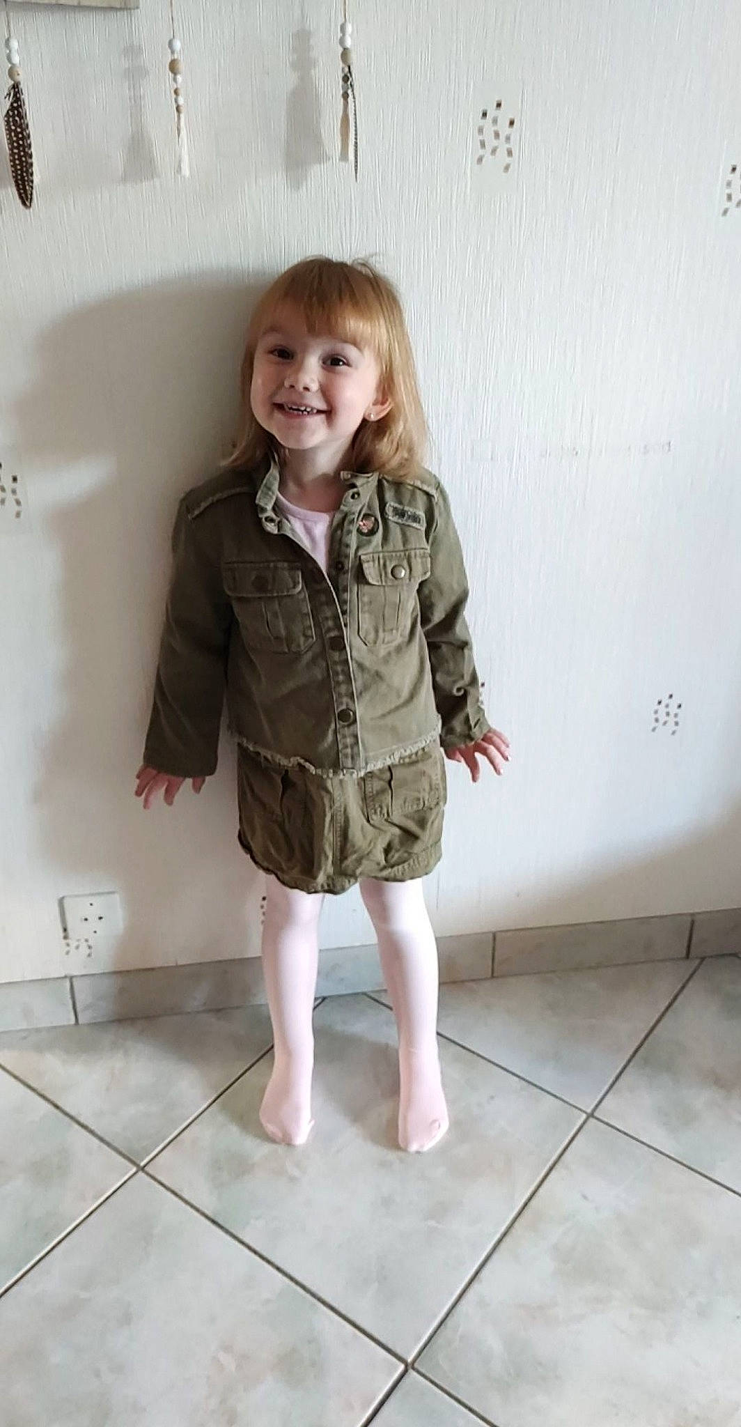 Julia participe au concours pour gagner de l'argent avec cette photo : baby_toddler_clothing, barefoot, blond, child, child_model, finger, floor, flooring, foot, hair, hand, human_body, joy, person, shoulder, sleeve, standing, tile, tile_flooring, toddler