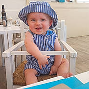 Côme participe au concours pour gagner de l'argent avec cette photo : baby, child, smiling, hat, striped_clothing, high_chair, indoor, cafe, wooden_chair, happy, person, infant, blue, white, seat, table, casual, cute, portrait, sitting