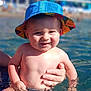 Côme participe au concours pour gagner de l'argent avec cette photo : baby, child, water, swimming, hat, colorful_hat, smiling, sunlight, summer, outdoor, hand, supporting_hand, skin, water_splash, happy, person, portrait, closeup, playful, vacation