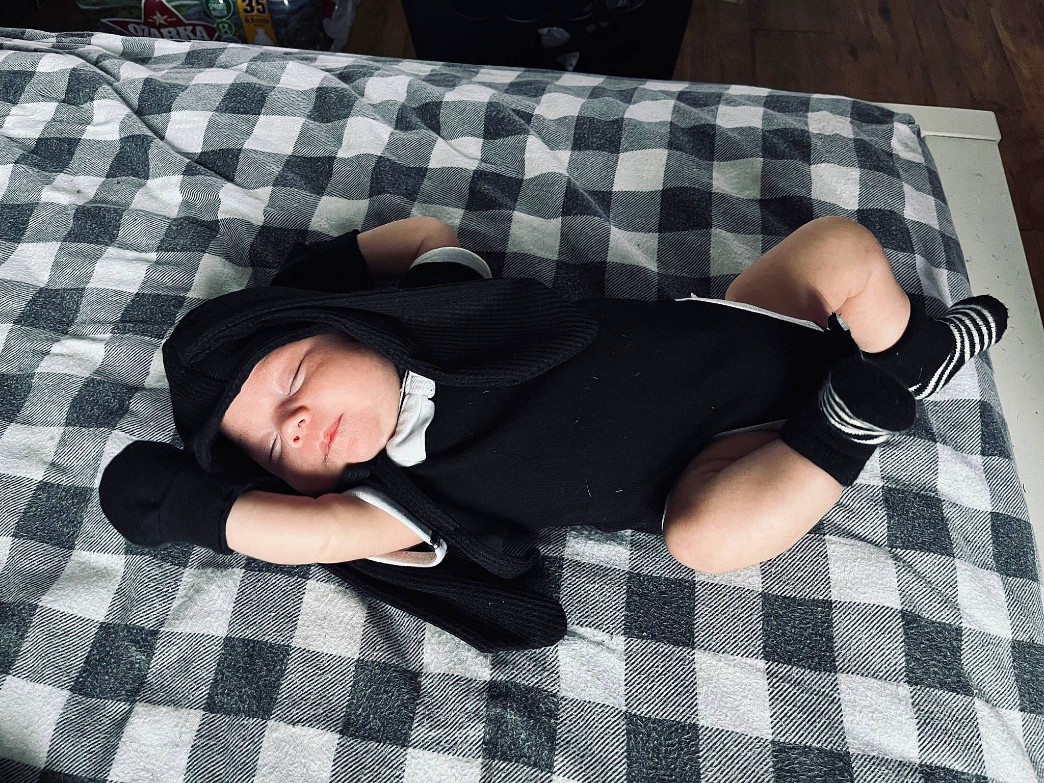 Grey is registered to the contest to win money with this photo: baby_toddler_clothing, black, child, comfort, design, finger, flooring, foot, headwear, human_leg, knee, lap, linens, pattern, person, plaid, sleeve, sock, tartan, textile