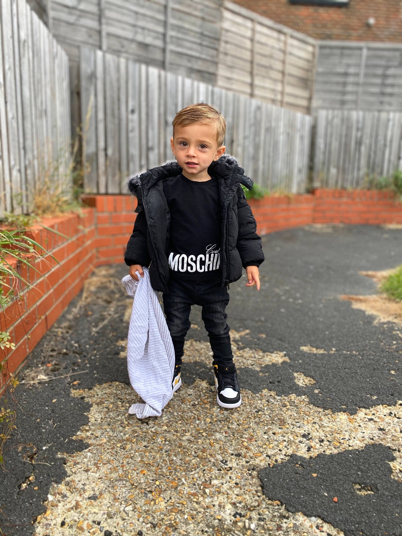 Bowen is registered to the contest to win money with this photo: asphalt, child, denim, fence, formal_wear, grass, jacket, leisure, people_in_nature, person, plant, recreation, road, road_surface, sidewalk, sleeve, soil, street_fashion, t_shirt, toddler