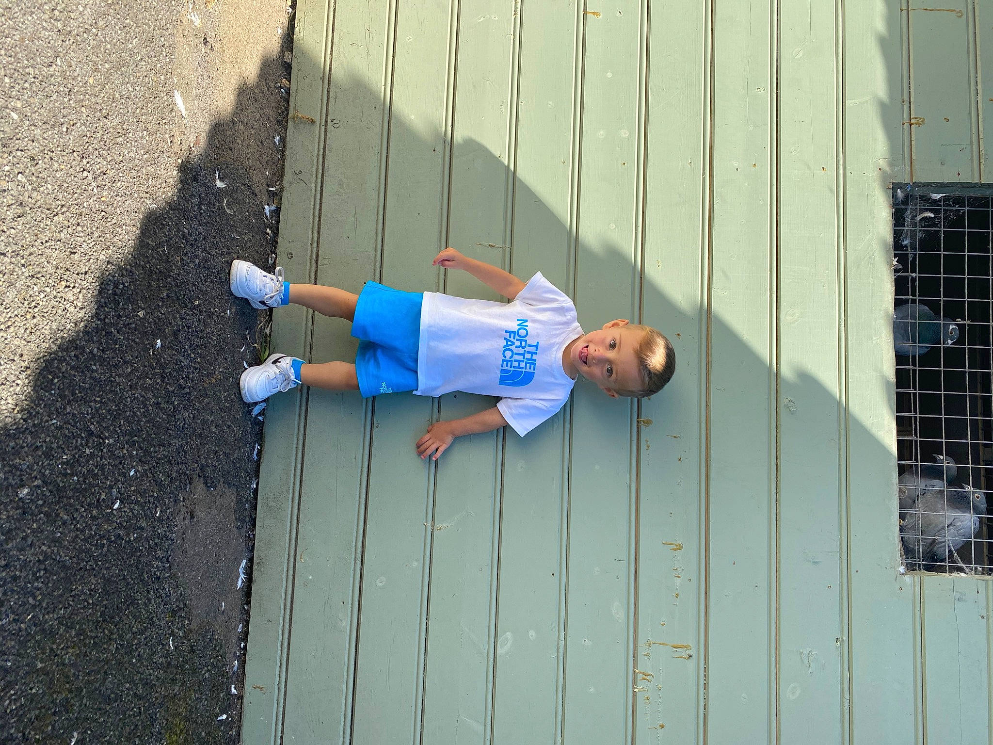 Bowen is registered to the contest to win money with this photo: asphalt, azure, building, child, concrete, electric_blue, facade, grass, human_leg, joy, leisure, person, road, road_surface, shadow, sidewalk, smile, street_fashion, t_shirt, tar