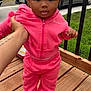 toddler, child, pink_clothing, tracksuit, bow, outdoor, deck, hand, holding, suburban, car, house, grass, wood, sneakers, person, face, curious, smile, portrait